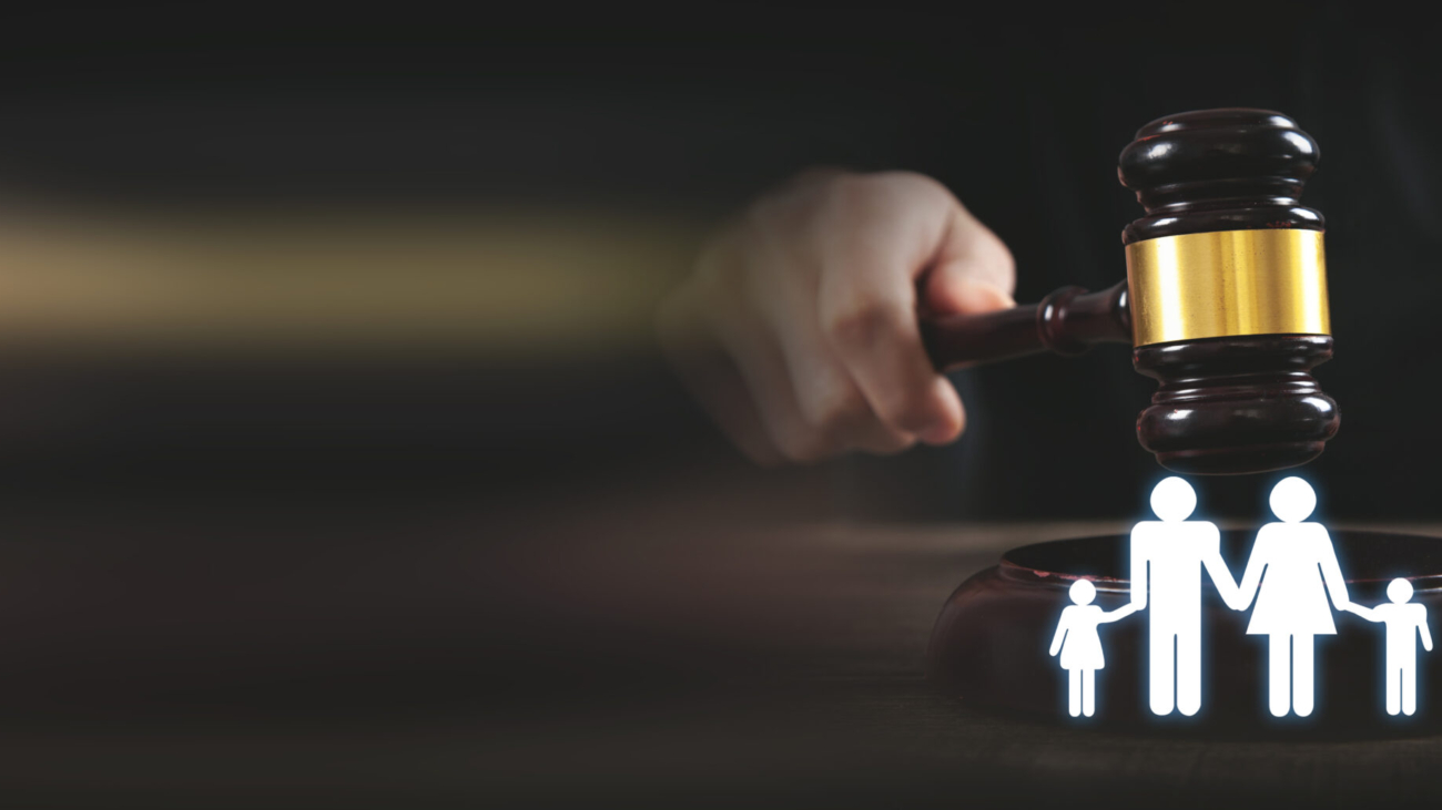 Male hand holding judge gavel with a family symbol. Family Law